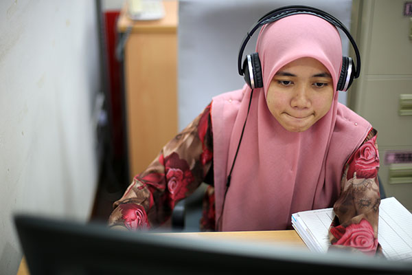 Girl in pink Hajib studying